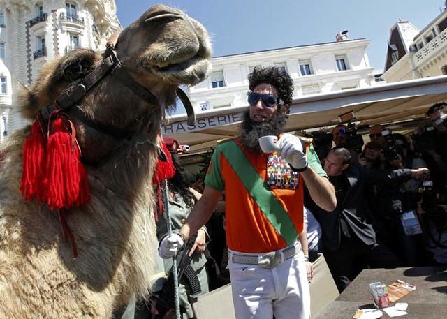 British actor Baron Cohen stands next to a camel during a photocall on the Croisette in Cannes